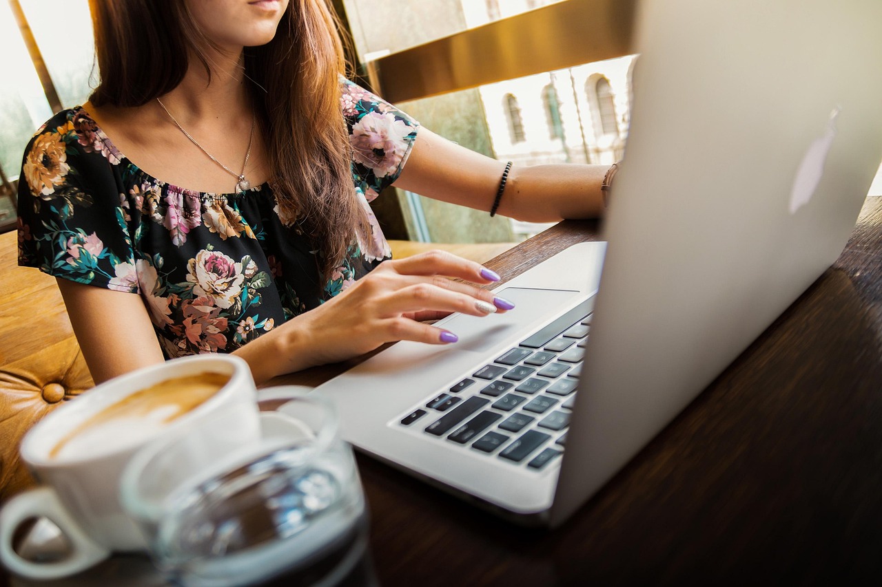 Woman providing tech and admin support using a laptopusing a laptop and ring light